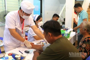 Các y, bác sĩ ân cần khám bệnh cho người dân. (Ảnh: HUY VŨ)