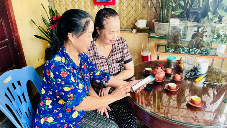 Người dân xã biên giới Phong Thổ cập nhật thông tin liên quan đến cuộc bầu cử thông qua thiết bị thông minh.