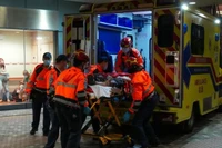 Đưa một người bị thương do vụ cháy đến cấp cứu tại bệnh viện. (Ảnh: Tân Hoa Xã)