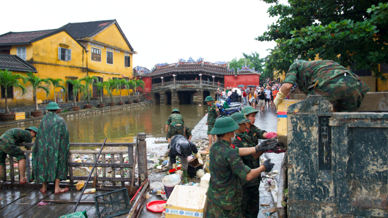 Các cán bộ, chiến sĩ Trường Quân sự Quân khu 5 thu dọn và vận chuyển lượng lớn rác tích tụ tại khu vực chùa Cầu Hội An sau lũ.