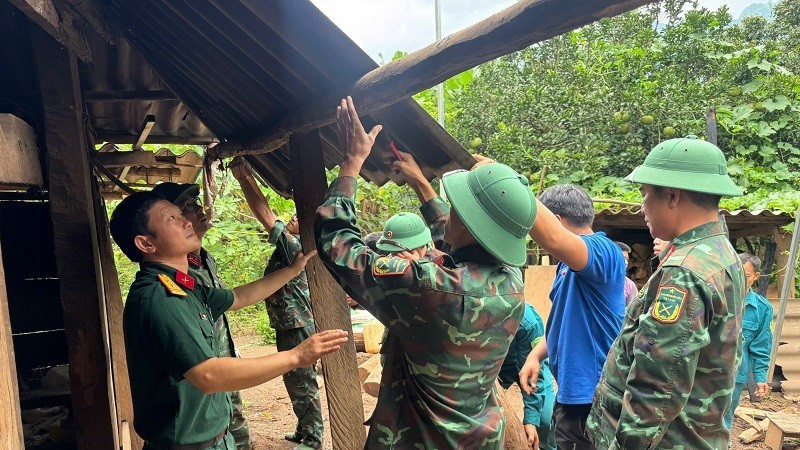 Cán bộ, chiến sĩ Ban Chỉ huy phòng phủ khu vực 4 Mường Ảng và cán bộ, công chức xã Pú Nhung giúp nhân dân tháo dỡ, di chuyển nhà cửa tránh nguy cơ sạt lở nghiêm trọng.