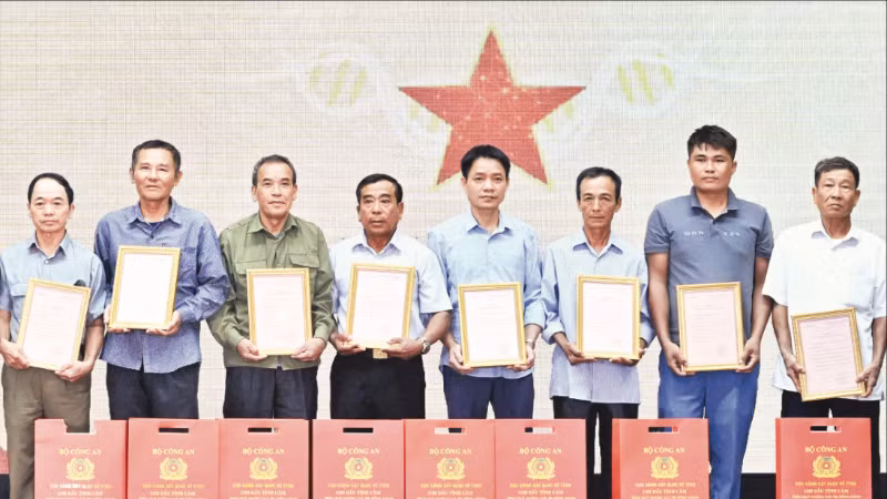 Đại diện các gia đình liệt sĩ Viện K20 nhận Thông báo kết quả giám định ADN hài cốt liệt sĩ. (Ảnh TRẦN HẢI)