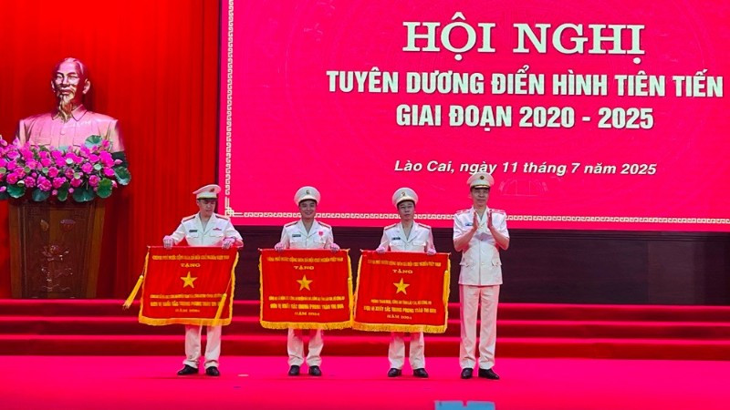 Thiếu tướng Cao Minh Huyền, Giám đốc Công an tỉnh Lào Cai trao cờ thi đua của Chính phủ cho các tập thể. (Ảnh: THANH SƠN)