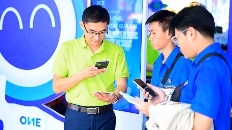 Nhân viên Ngân hàng ACB giới thiệu với khách hàng các tiện ích thanh toán số. (Ảnh ACB)