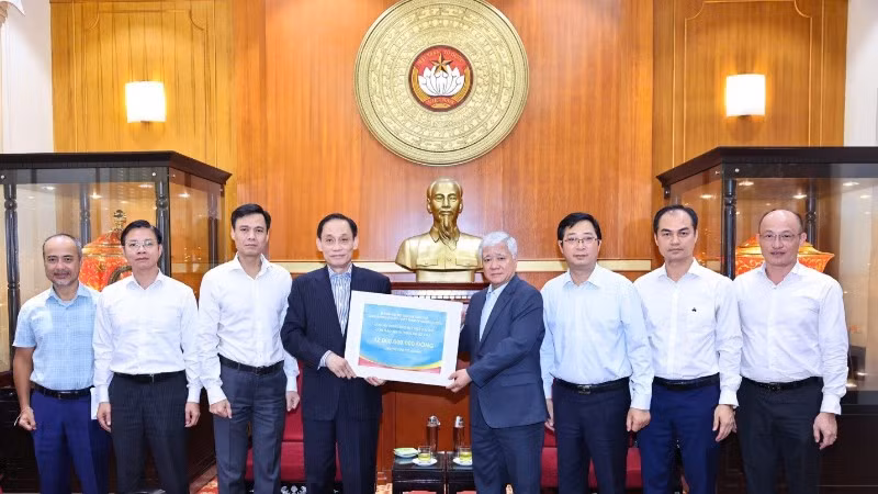 Đồng chí Đỗ Văn Chiến (thứ 4 từ phải sang) tiếp nhận kinh phí ủng hộ từ đồng chí Lê Hoài Trung. 