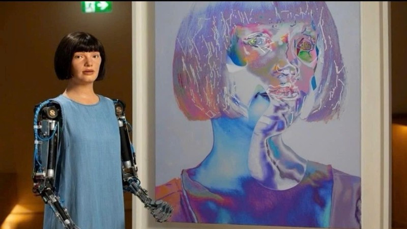 Một robot hình người có tên Ai-Da bên bức tranh chân dung tự vẽ trưng bày tại Triển lãm nghệ thuật mới ở London.