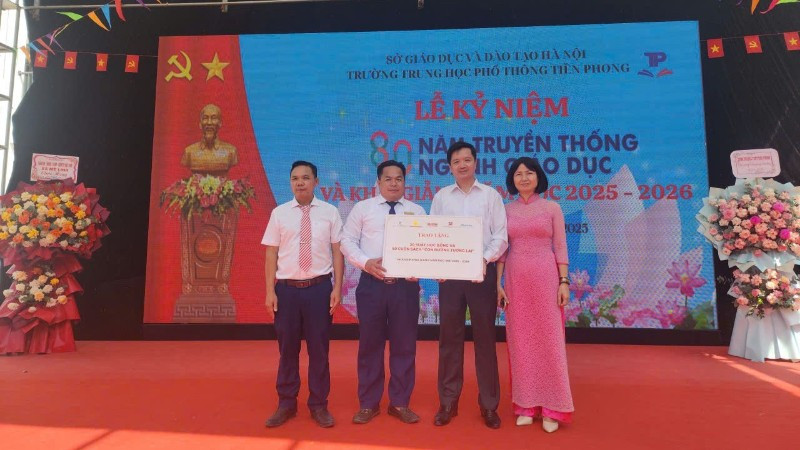 Đại diện Báo Nhân Dân trao biểu trưng 20 suất học bổng đến lãnh đạo Trường trung học phổ thông Tiền Phong. 
