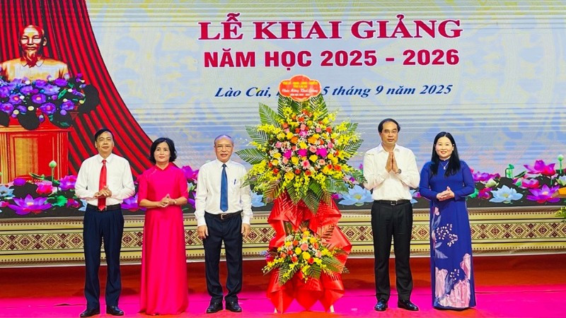 Bí thư Tỉnh ủy Trịnh Xuân Trường tặng hoa chúc mừng nhà trường. (Ảnh: THANH SƠN)