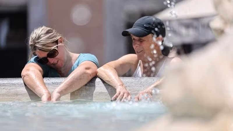 Du khách giải nhiệt tại đài phun nước ở Roma, Italia. (Ảnh: TÂN HOA XÃ) 