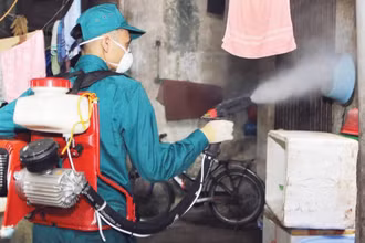 Cán bộ y tế phun hóa chất phòng chống bệnh sốt xuất huyết tại các hộ gia đình ở Hà Nội.