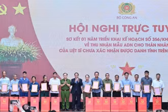 Thủ tướng Chính phủ Phạm Minh Chính trao Thông báo kết quả giám định ADN hài cốt liệt sĩ cho đại diện thân nhân các gia đình liệt sĩ. (Ảnh: TRẦN HẢI) 