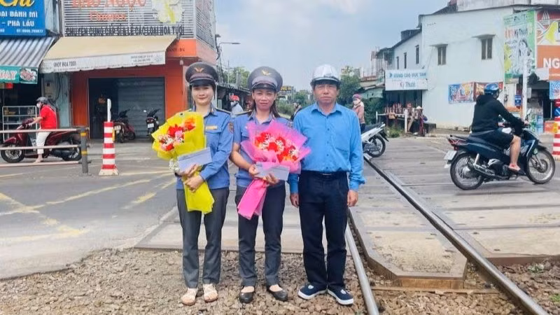 Đại diện lãnh đạo Công ty cổ phần Đường sắt Sài Gòn động viên, khen thưởng hai nhân viên gác chắn.