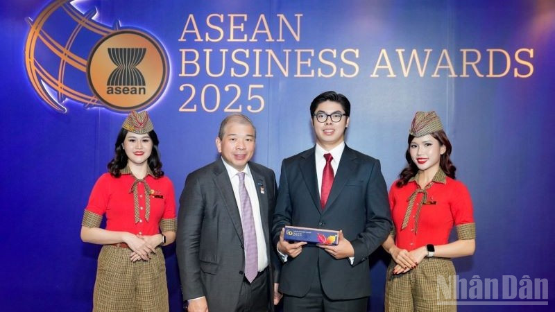 Ông Teo Siong Seng, Chủ tịch Hội đồng Tư vấn Kinh doanh ASEAN tại Singapore (thứ hai từ trái sang), chúc mừng và trao giải thưởng cho đại diện Vietjet.