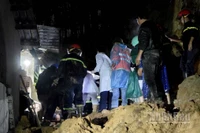 Lực lượng chức năng khẩn trương cứu hộ bé gái bị vùi lấp.