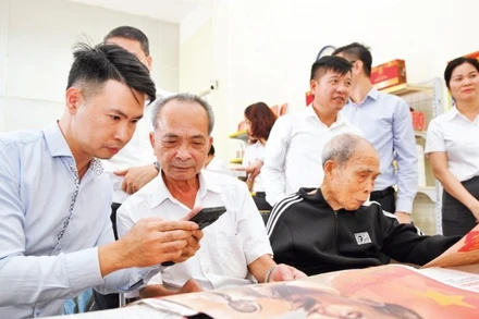 Người dân tìm hiểu phụ trương dự thảo các văn kiện trình đại hội XIV của Đảng tại điểm bưu điện văn hóa xã Dạ Trạch, tỉnh Hưng Yên. (Ảnh: THẾ ĐẠI)