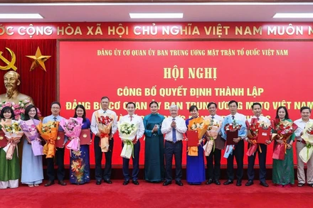 Các đồng chí Đỗ Văn Chiến, Hà Thị Nga (thứ tám và chín từ phải sang) trao Quyết định, tặng hoa chúc mừng người đứng đầu các tổ chức đảng ở các đơn vị trực thuộc Cơ quan Ủy ban Trung ương Mặt trận Tổ quốc Việt Nam.