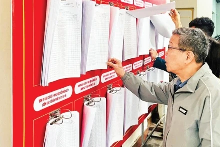 Cử tri phường Văn Miếu-Quốc Tử Giám (Hà Nội) rà soát, kiểm tra thông tin tại danh sách cử tri. (Ảnh: TRẦN LONG)