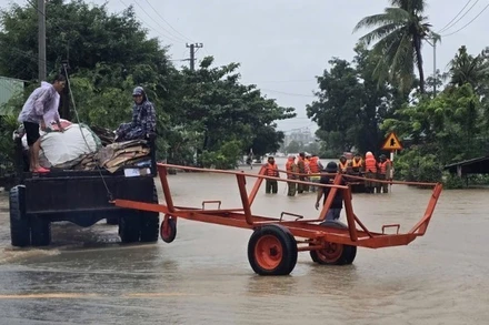 Người dân Gia Lai cùng lực lượng chức năng hỗ trợ nhau trong quá trình di dời đến nơi an toàn. (Ảnh: nhandan.vn)