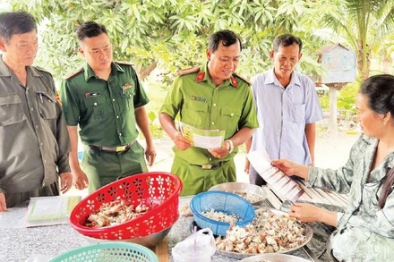 Trung tá Châu Văn Nát cùng đại diện Bộ đội Biên phòng và thành viên Đội dân phòng cơ động đến nhà dân tuyên truyền phòng chống lừa đảo trực tuyến.