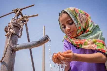 Một cô bé đang uống nước từ máy bơm tay tại Pakistan. (Nguồn: UN) 