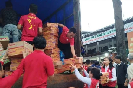 Cán bộ Hội Chữ thập đỏ Thành phố Hồ Chí Minh bốc xếp hàng hóa, thực phẩm lên xe để hỗ trợ các tỉnh bị thiên tai phía bắc. 