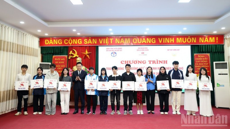 Đồng chí Phan Văn Hùng, Phó Tổng Biên tập Báo Nhân Dân và đồng chí Lê Thị Thanh Trà, Phó Chủ tịch Hội đồng nhân dân tỉnh Tuyên Quang trao học bổng cho các sinh viên nghèo vượt khó.
