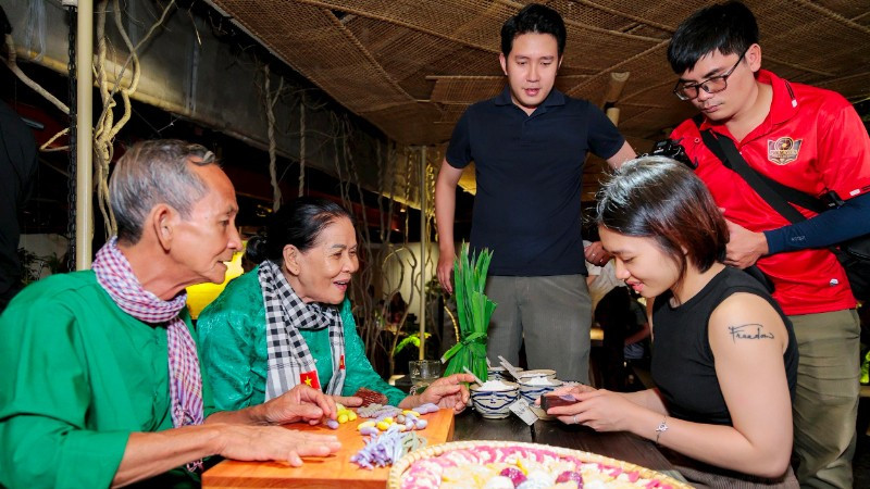 Hương vị đất phương nam Vợ chồng nghệ nhân Trương Thị Chiều hướng dẫn du khách trải nghiệm làm bánh dân gian.