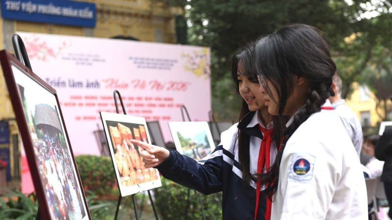 Các em học sinh say sưa ngắm những tác phẩm trong triển lãm.