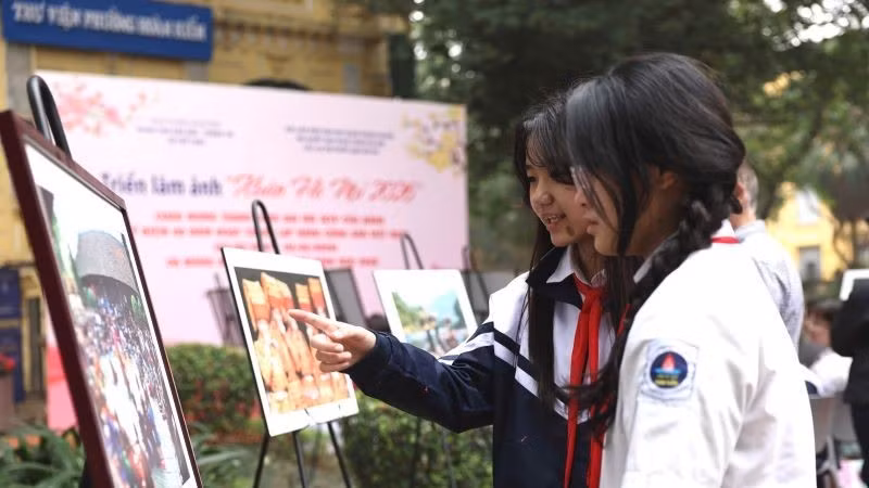 Các em học sinh say sưa ngắm những tác phẩm trong triển lãm.