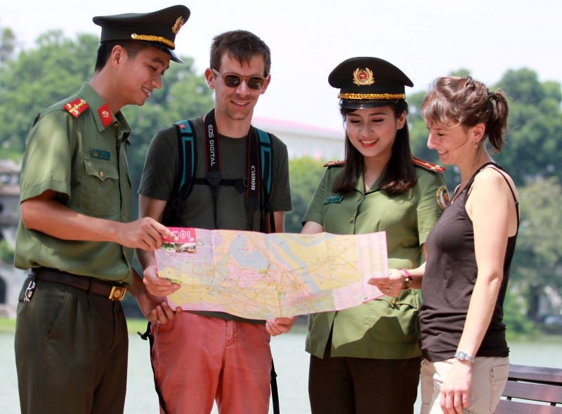 Chiến sĩ Công an thành phố Hà Nội hỗ trợ khách du lịch nước ngoài tham quan Thủ đô. (Ảnh: LAM THANH) 17-8-bt-5.jpg