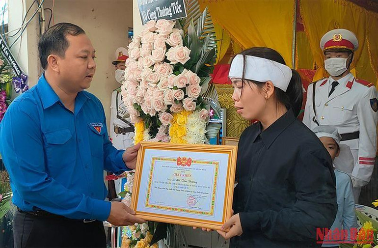 Bí thư Tỉnh đoàn Đồng Tháp Huỳnh Minh Thức trao tặng giấy khen cho đồng chí Hồ Tấn Dương đã dũng cảm hy sinh khi đang làm nhiệm vụ truy bắt tội phạm. (Ảnh: HỮU NGHĨA)