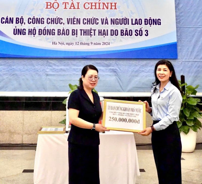 Bà Đinh Thị Kim Giang – Phó Chủ tịch Công đoàn Ủy ban Chứng khoán Nhà nước, đại diện Công đoàn Ủy ban Chứng khoán Nhà nước (bên phải) trao tặng số tiền đóng góp cho bà Nguyễn Thị Kim Nhung – Chủ tịch Công đoàn Bộ Tài chính (bên trái) tại Lễ phát động của Công đoàn Bộ Tài chính diễn ra vào ngày 12/9/2024