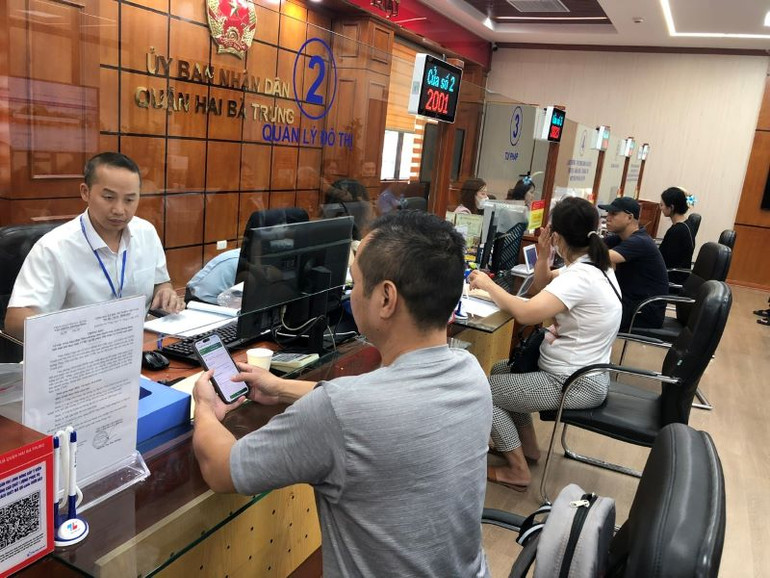 Người dân làm thủ tục hành chính tại bộ phận Một cửa quận Hai Bà Trưng. (Ảnh: Bích Ngọc)