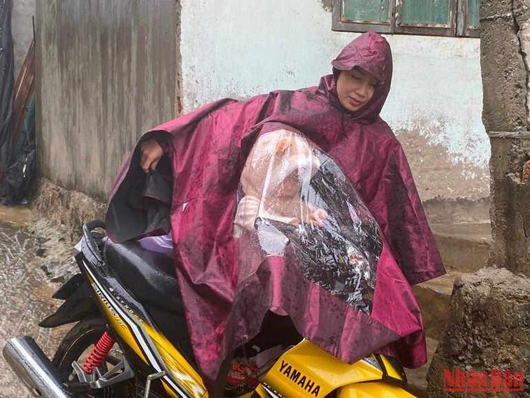 Mẹ con chị Nguyễn Thị Thu ở thôn Phước Thiện, xã Bình Hải di chuyển lên khu vực tạm lánh của xã để tránh bão Noru.