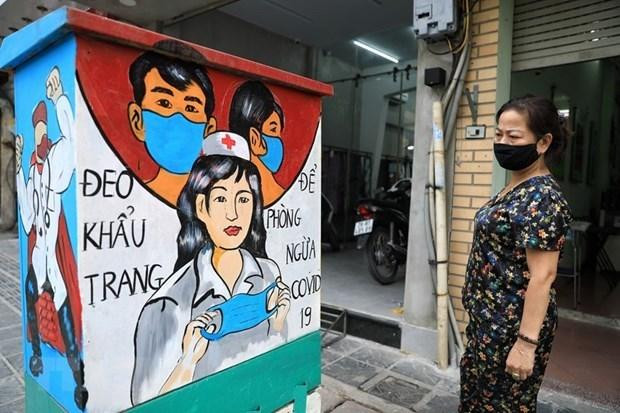 Người dân xem những bức tranh cổ động về công tác phòng, chống dịch Covid-19. (Ảnh: Thành Đạt/TTXVN) Người dân xem những bức tranh cổ động về công tác phòng, chống dịch Covid-19. (Ảnh: Thành Đạt/TTXVN)