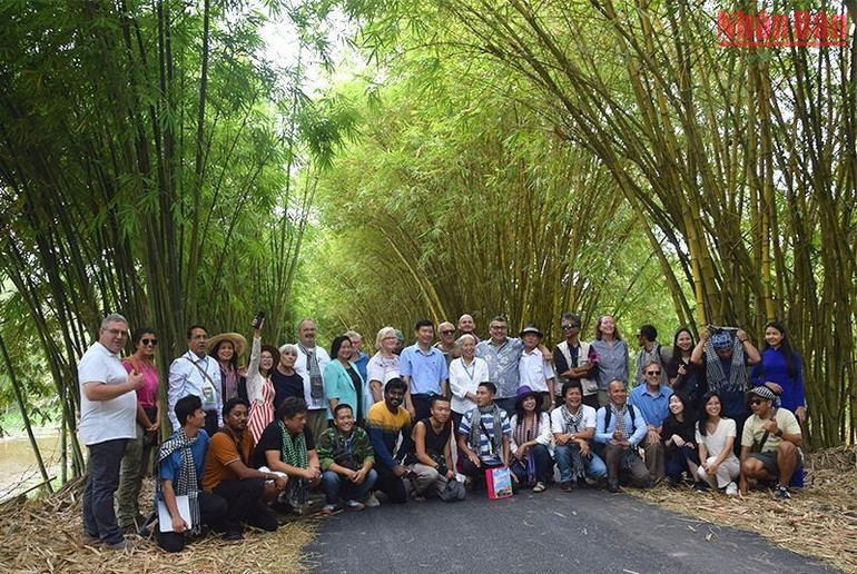 Đoàn chuyên gia cùng lãnh đạo tỉnh tham quan và chụp ảnh tại con đường tre ở Khu du lịch sinh thái Gáo Giồng. (Ảnh: HỮU NGHĨA)