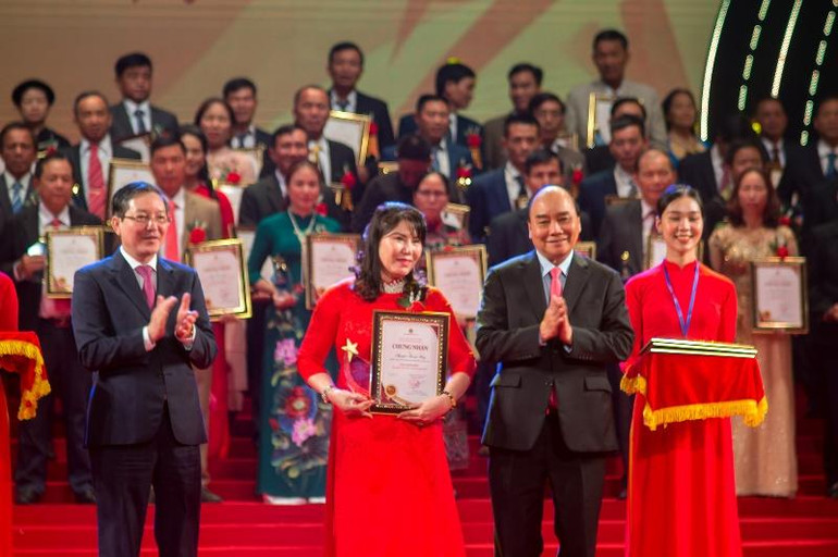 Đồng chí Nguyễn Xuân Phúc, Ủy viên Bộ Chính trị, Chủ tịch nước Cộng hòa xã hội chủ nghĩa Việt Nam; và đồng chí Lương Quốc Đoàn, Ủy viên Trung ương Đảng, Chủ tịch Ban Chấp hành Trung ương Hội Nông dân Việt Nam, trao danh hiệu và kỷ niệm chương cho các nông dân xuất sắc thuộc lĩnh vực Khởi nghiệp, sáng chế, chuyển đổi số. (Ảnh: TRUNG HƯNG)