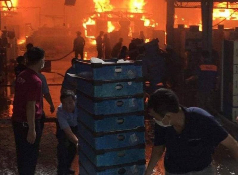Công nhân di dời đồ đạc ra khỏi khu vực xưởng bị cháy.