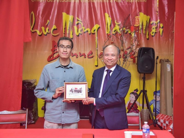 Đại sứ Đinh Toàn Thắng trao tặng bức tranh tem Chủ tịch Hồ Chí Minh do Bưu điện Pháp phát hành nhân dịp kỷ niệm 100 năm Người đặt chân đến Pháp cho Hội Sinh viên Việt Nam tại vùng Aix-Marseille. (Ảnh: MINH DUY)