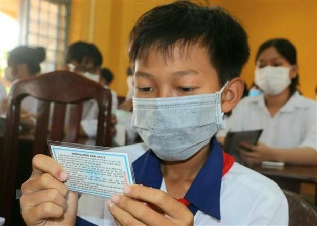 Học sinh có hoàn cảnh khó khăn nhận thẻ bảo hiểm từ nhà hảo tâm. (Ảnh minh họa: Duy Khương/TTXVN)