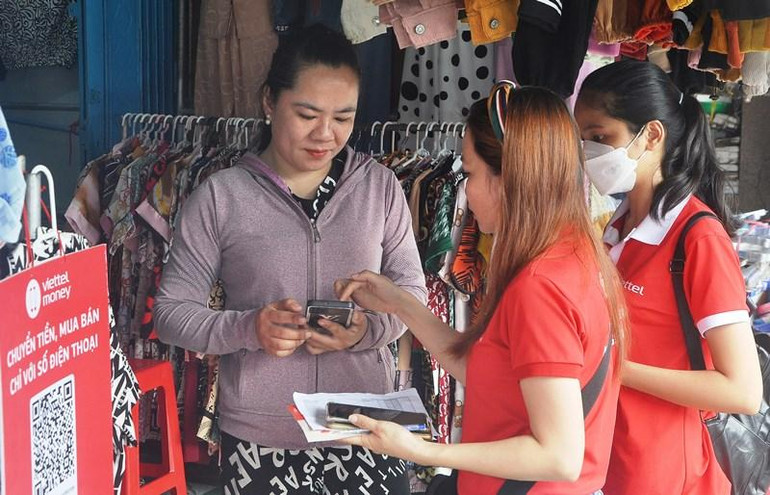 Nhân viên Viettel Tiền Giang hướng dẫn tiểu thương ứng dụng mô hình chợ 4.0 - không dùng tiền mặt.