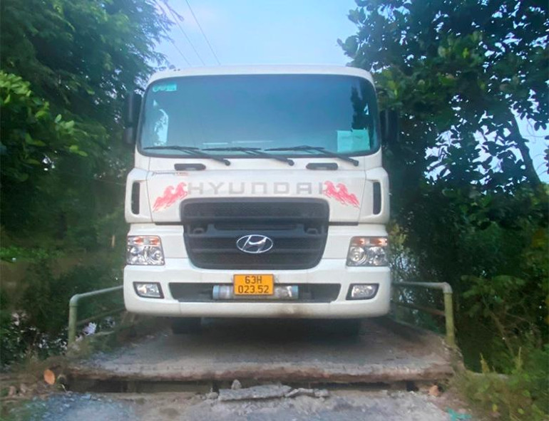 Xe tải nằm chắn trên cầu khiến việc đi lại trên tuyến đường nông thôn gặp khó khăn.