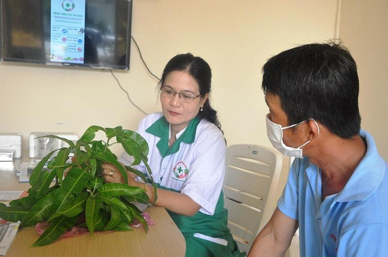 Tiến sĩ Trần Thị Mỹ Hạnh (bên trái) “bắt bệnh” trên cây xoài của ông Phạm Văn Chí.