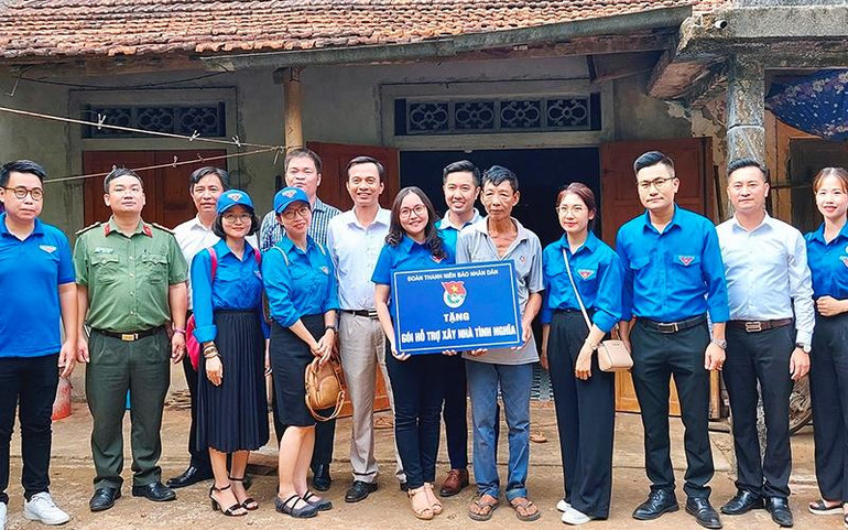 Đại diện Đoàn Thanh niên các đơn vị trao tượng trưng gói hỗ trợ xây nhà tình nghĩa tặng ông Trần Hữu Nguyên (thứ 5 từ phải sang).