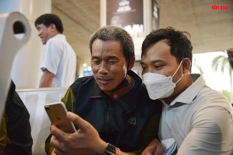 Một thuyền viên mượn điện thoại của người đồng hương để điện thoại về nhà.