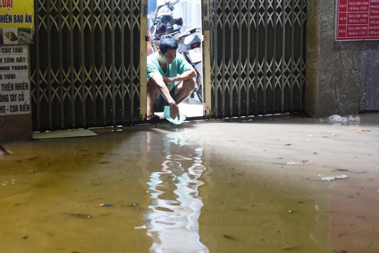 Người dân sống bên đường Quốc lộ 51 thức trắng đêm để tát nước ra khỏi nhà.