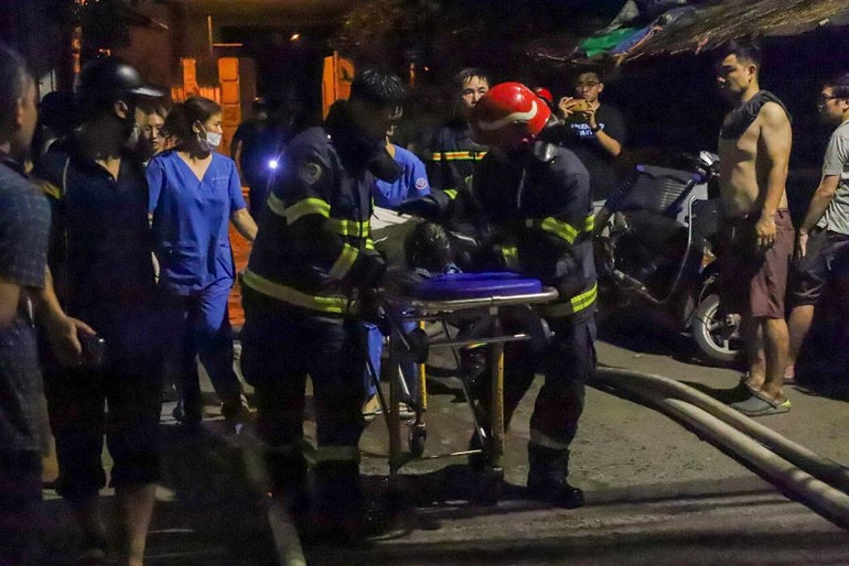 Lực lượng chữa cháy đưa nạn nhân ra ngoài.