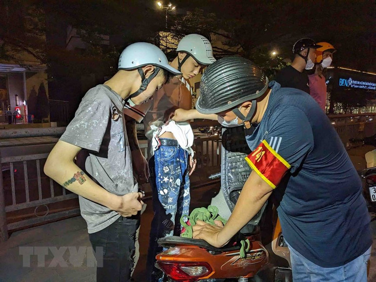 Tổ công tác Y9/141 hóa trang kiểm tra và bắt giữ 1 trường hợp đi xe máy điều khiển xe chạy tốc độ cao, lạng lách đánh võng, nẹt pô, gây mất trật tự công cộng. (Ảnh: Phạm Kiên/TTXVN)