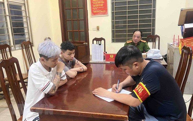 Tổ công tác Y9/141 hóa trang lập biên bản bàn giao nhiều thanh, thiếu niên điều khiển phương tiện đi xe tốc độ cao, lạng lách đánh võng, nẹt pô gây mất trật tự an toàn giao thông cho Công an phường. (Ảnh: Phạm Kiên/TTXVN)