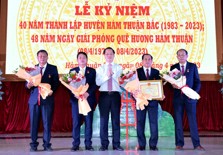 Chủ tịch Ủy ban nhân dân tỉnh Bình Thuận Đoàn Anh Dũng (áo trắng, đứng giữa) trao Bằng khen và tặng hoa chúc mừng cán bộ, nhân dân huyện Hàm Thuận Bắc.